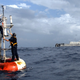 Dos técnicos reparan una boya Atlas como la que marca Null Island. Foto: NOAA